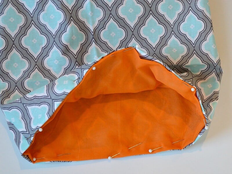 fabric gift bag with pins holding the orange interior to the blue and grey exterior fabric