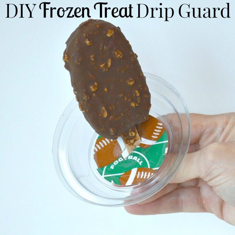 close up of a hand holding an ice cream bar with a drip guard