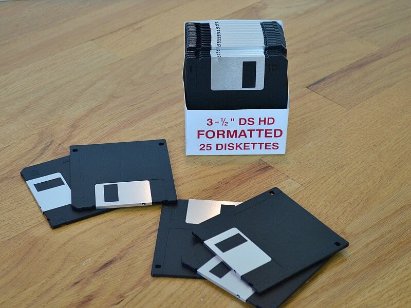 box of computer diskettes with some diskettes scattered on table