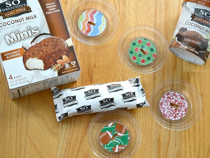 overhead view of ice cream bar, box and tub of ice cream and 4 clear decorated lids with slits in middle