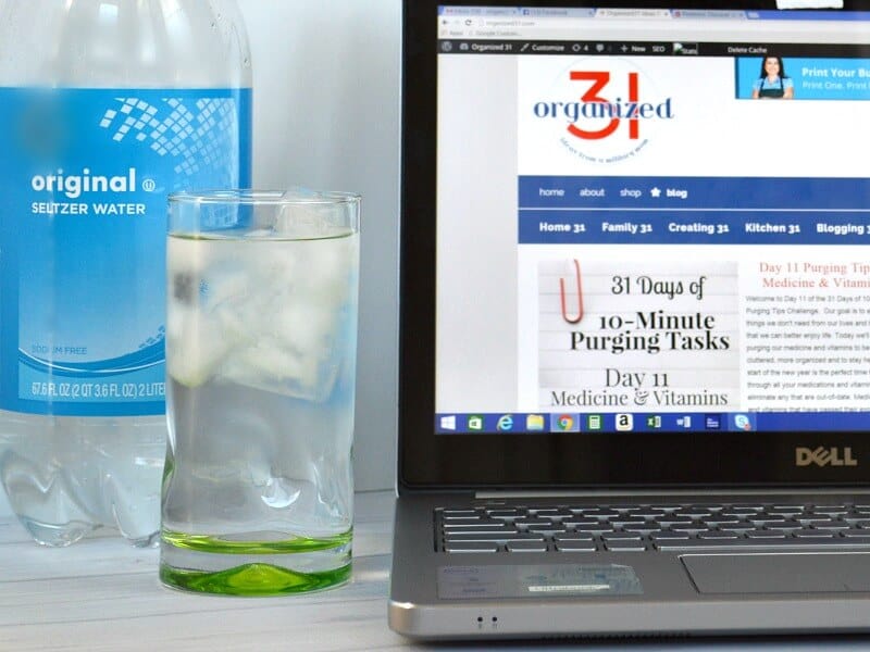 glass of water next to bottle of water and laptop computer