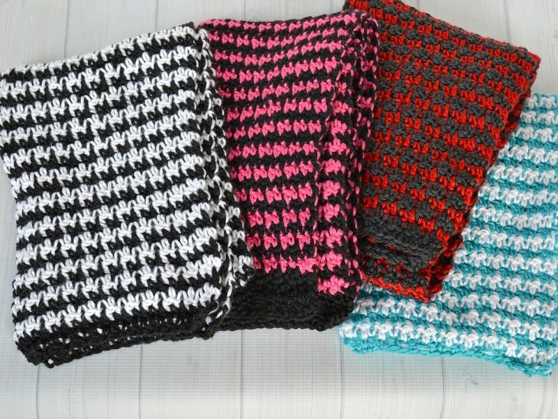 4 folded houndstooth scarves on white table