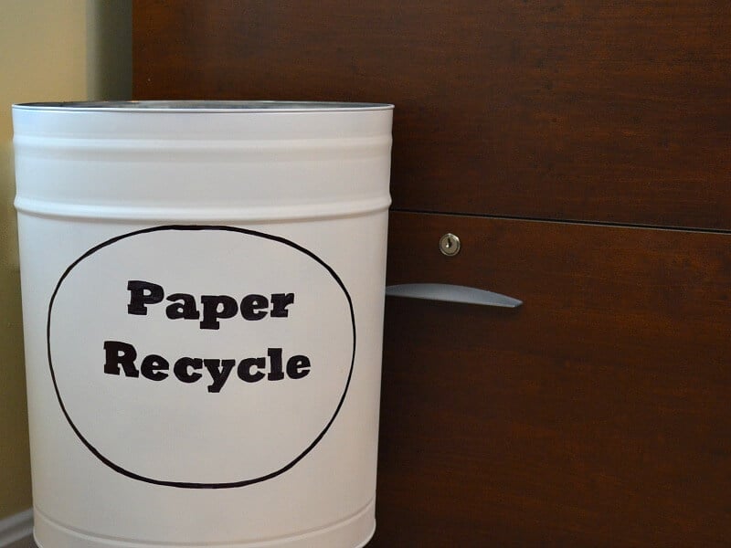 white paper recycling bin in front of wood filing cabinet