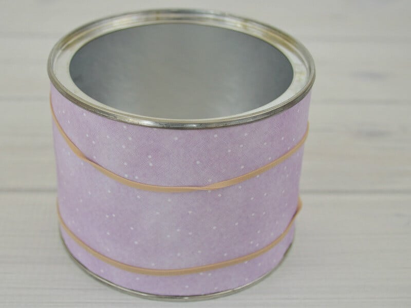 can with purple paper held in place by rubber bands