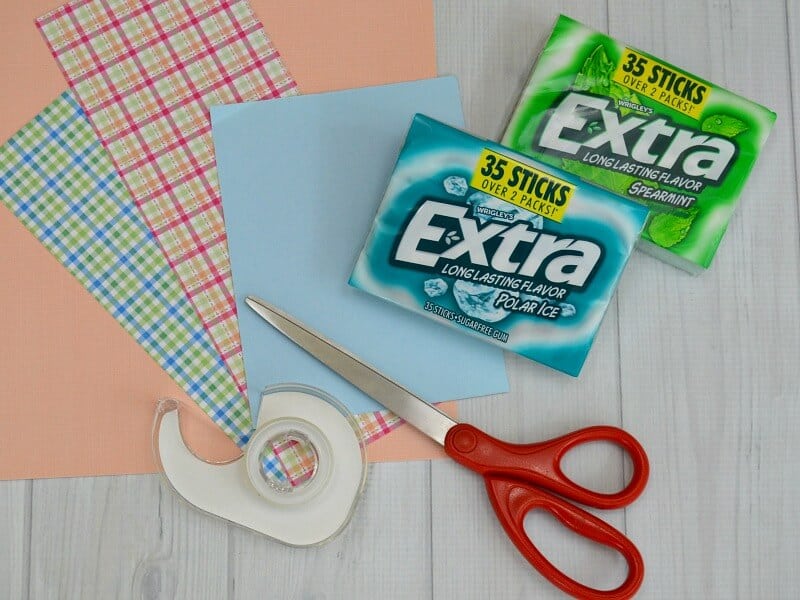 overhead view of decorative paper, tape, scissors and 2 packs of gum