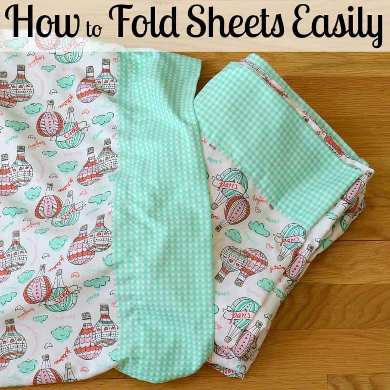 folded sheets on wood table with title text reading How to Fold Sheets Easily