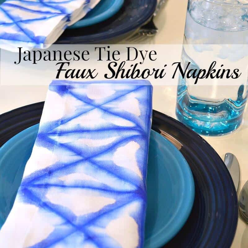 close up of blue and white napkin on blue place setting on white table