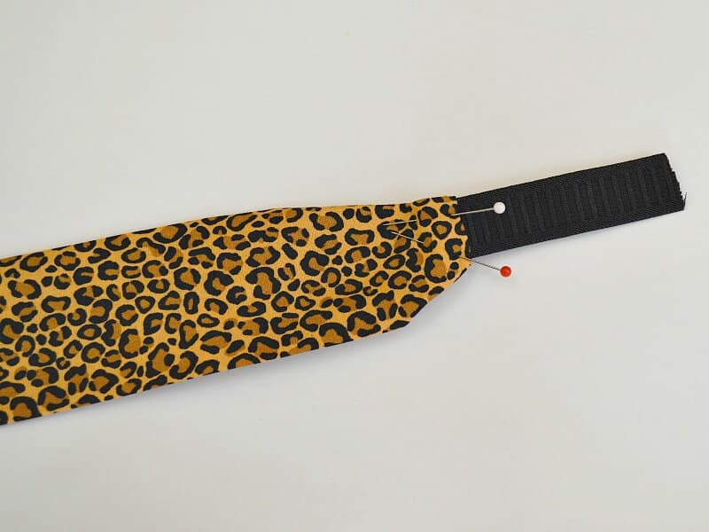pins holding black elastic to edge of cheetah print headband