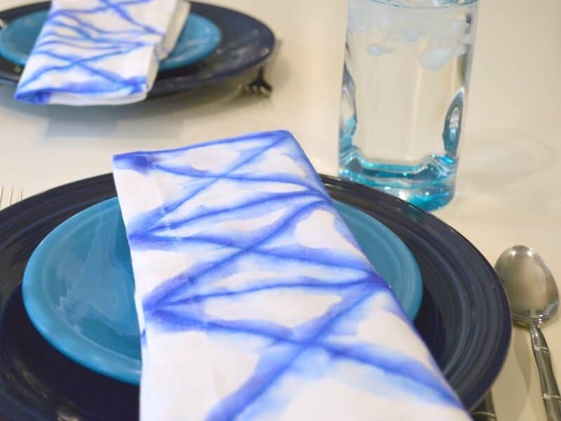 blue and white shibori napkins on blue plates with blue glass of water