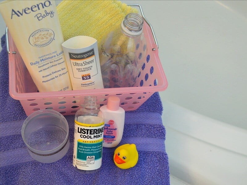 pink basket with bottles and purple towel next to bath tub