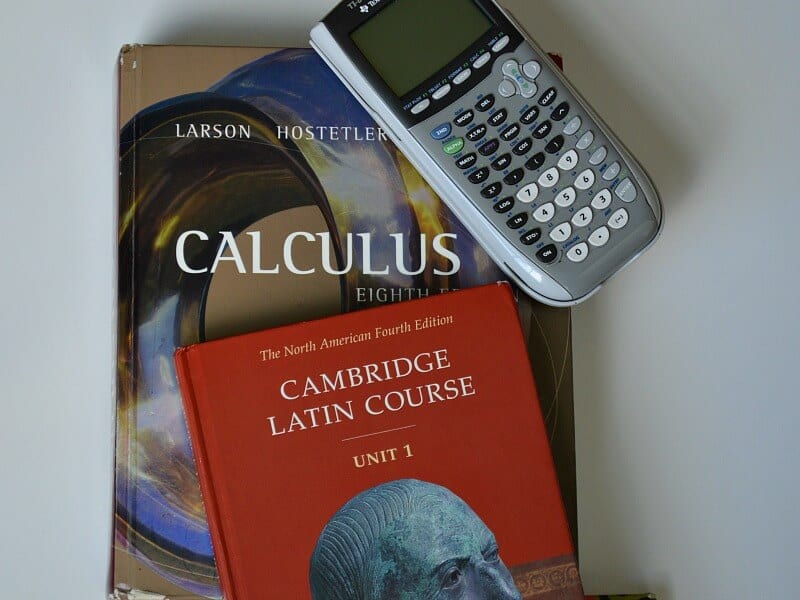 overhead view of stack of college text books and calculator