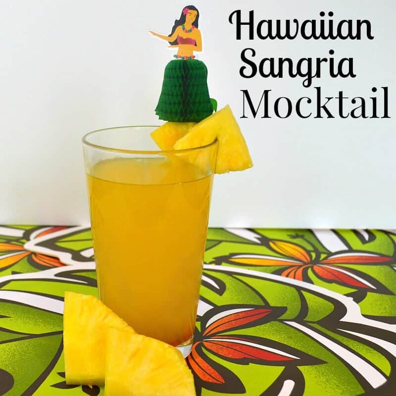 glass of orange drink with hula girl embellishment.