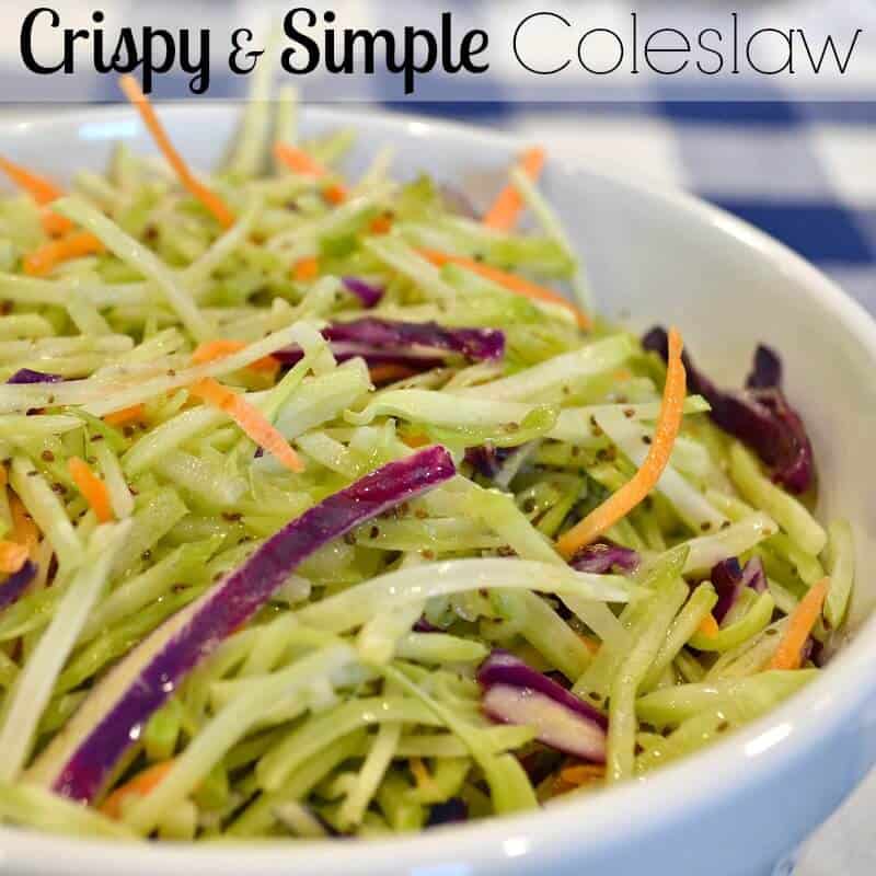 white bowl of colorful coleslaw on blue and white tablecloth.