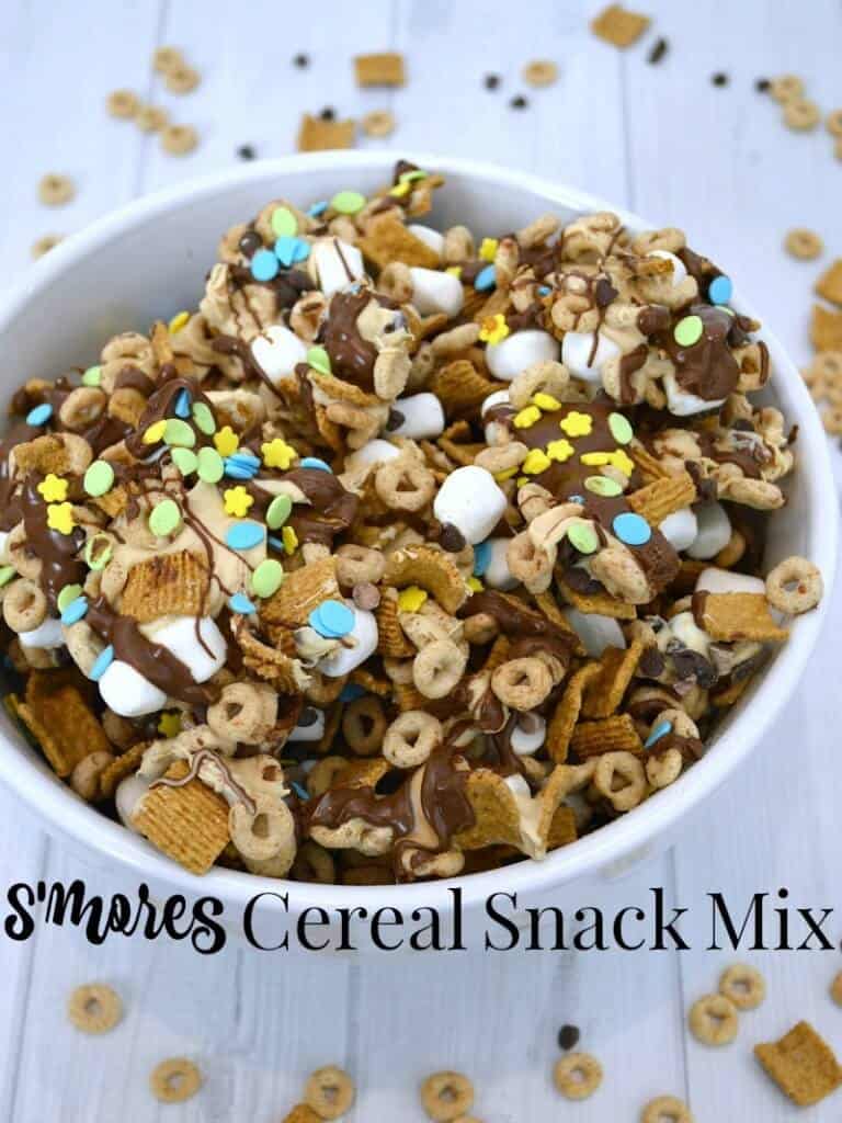 large white bowl of cereal snack mix with marshmallows, chocolate drizzle and colorful candies