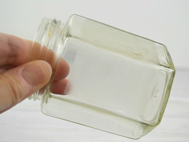 hand holding jar showing label residue
