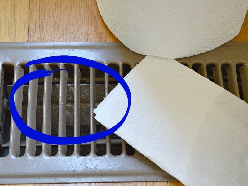paper towels next to floor vent with cobwebs