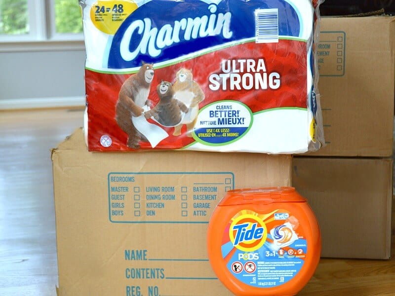 moving boxes with package of toilet paper and laundry detergent pods
