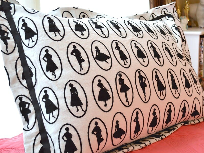 Close up side view of black and white pillow sham with fashion silhouettes 