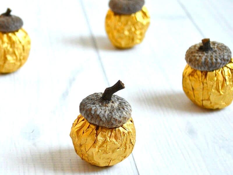 close up of acorns made from gold foil candy with acorn tops
