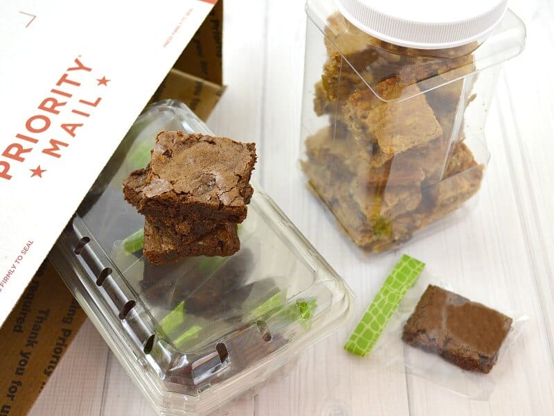 overhead view of brownies packed in clear containers with shipping box nearby