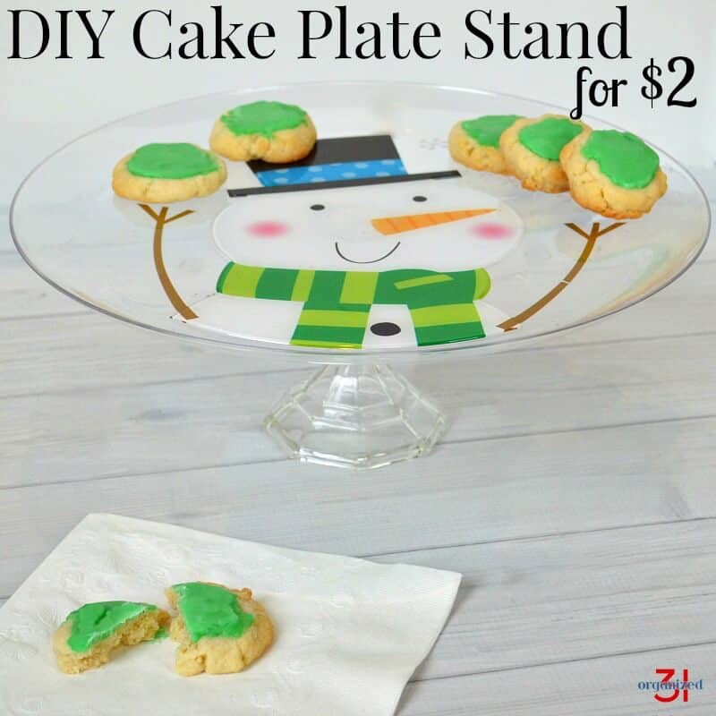 snowman cake stand with green frosted cookies with title text reading DIY Cake Plate Stand for $2