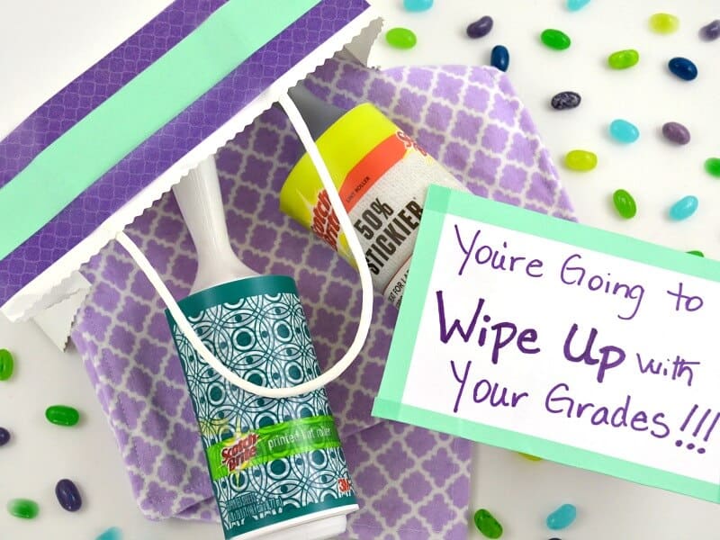 overhead view of items in a gift bag with gift tag that says "You're going to wipe up with your grades!!"