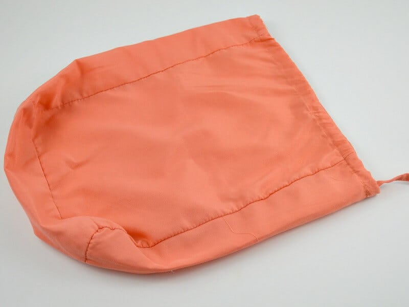 small orange fabric bag on white table