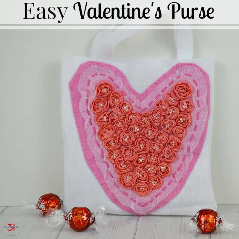 white bag with handles and pink heart with ribbon flowers.
