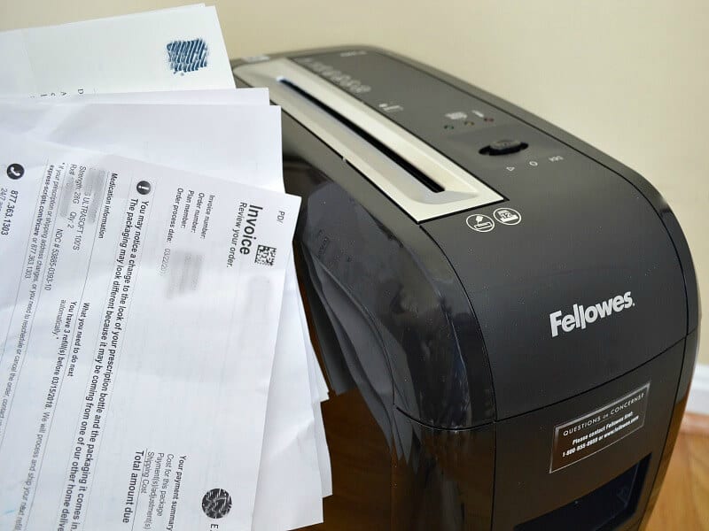 stack of papers next to paper black shredder