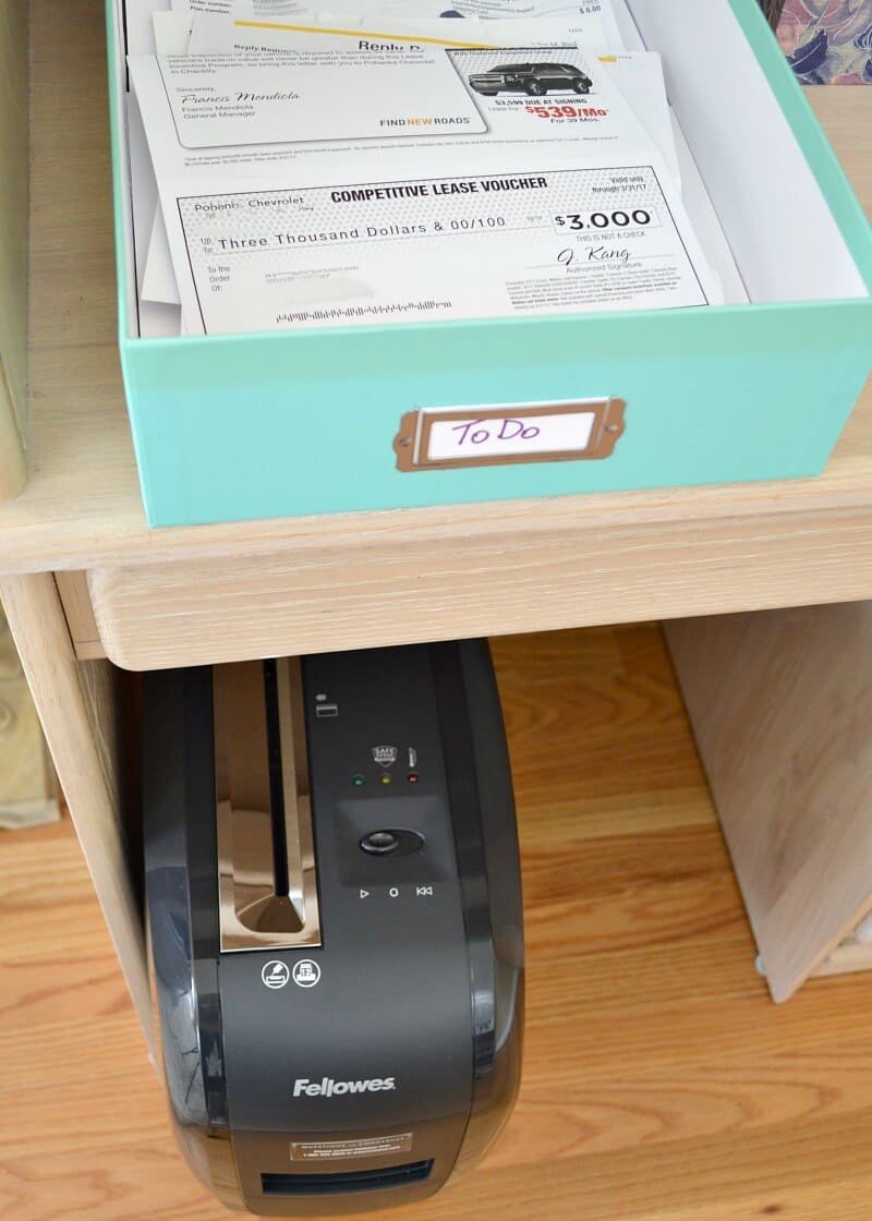 overhead view of open document box filled with papers and paper shredder under the table