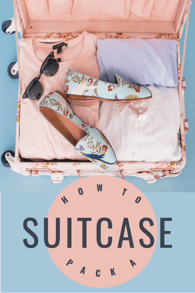 overhead view of open suitcase with sunglasses and Loral shoes