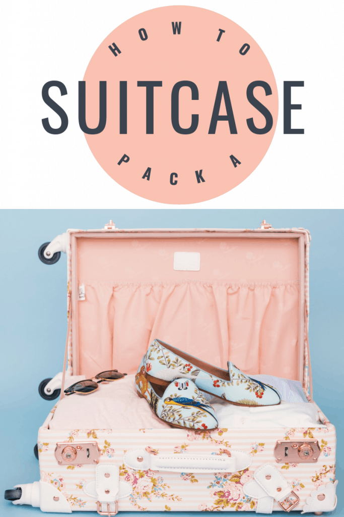 open suitcase with pink lining and floral shoes