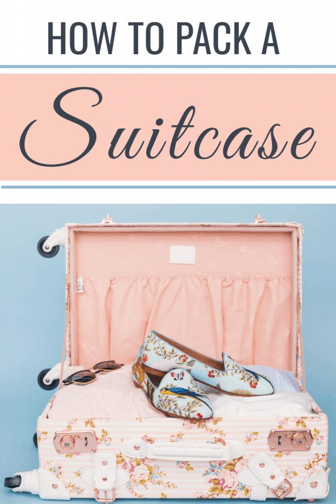 open suitcase with pink lining and floral shoes