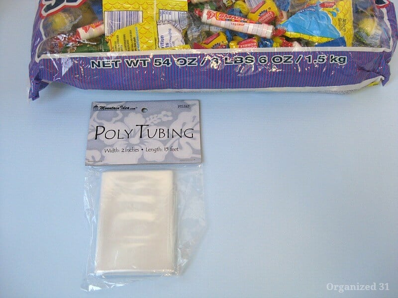 large bag of candy with package of poly tubing on blue table