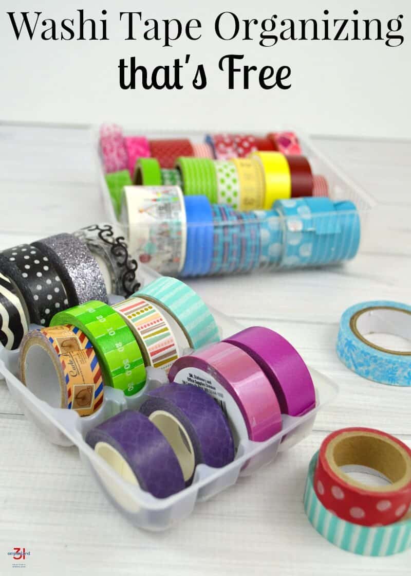  2 trays of neatly organized colorful rolls of washi tape on white wood table with a few rolls laying on the table with title text reading Washi Tape Organizing That's Free