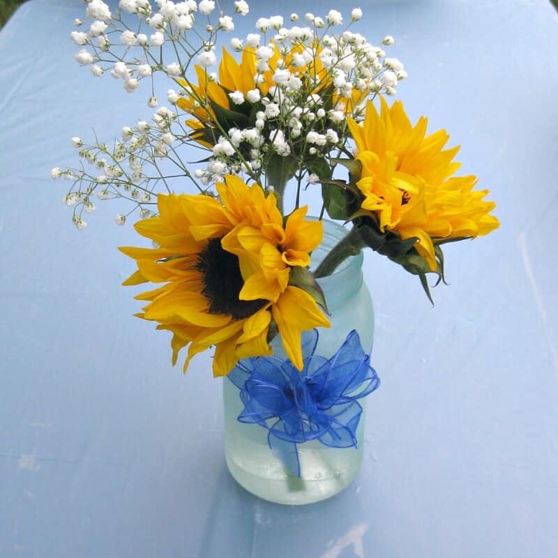 light blue jar with blue bow and sunflowers and baby's breath