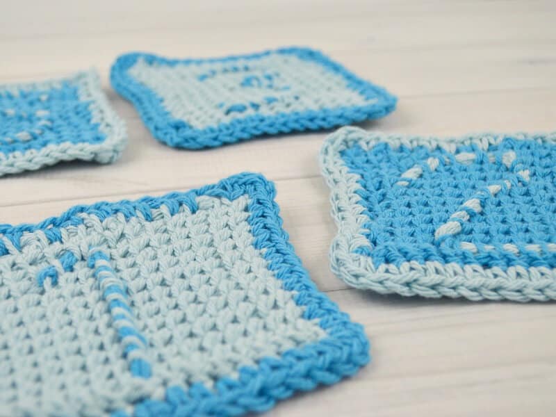 side view of crocheted numbered coasters on white table