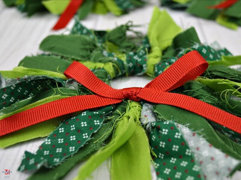 Close up of rustic fabric mini wreath with red bow