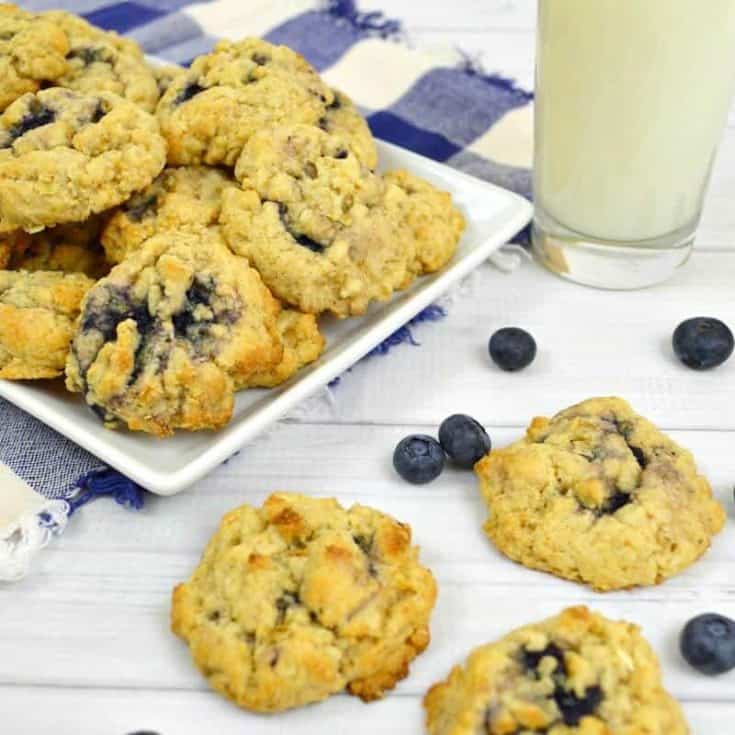 blueberry oatmeal cookies with blueberries and glass of milk