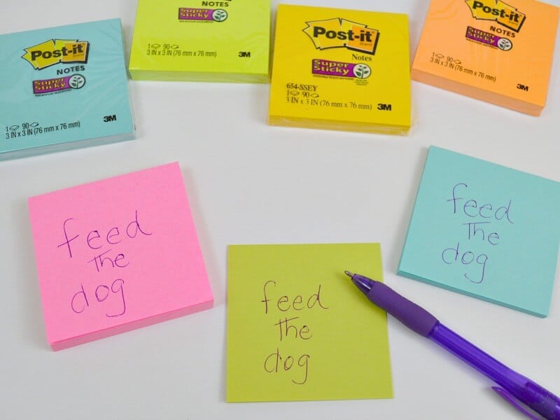 sticky note reminders and blue pen with sticky note packets in background