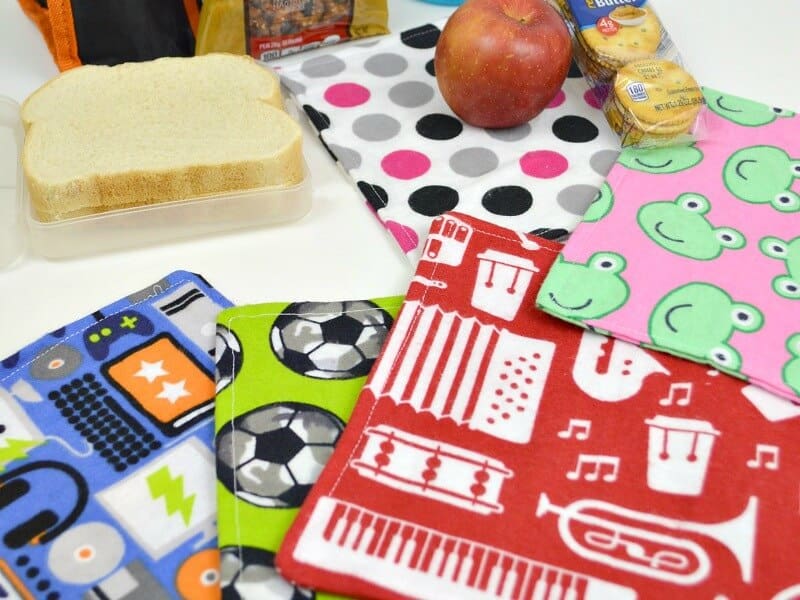 stack of colorful fabric cloth napkins with lunchbox and food items