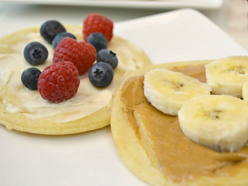close up of banana slices on waffle with peanut butter and waffle with berries