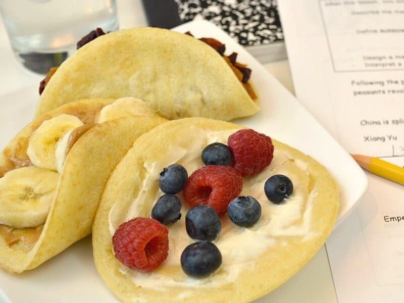 waffles with fruit folded like tacos and school papers and pencil in background