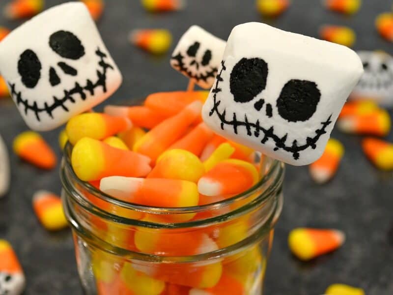 3 marshmallows with skeleton  faces in jar filled with candy corn