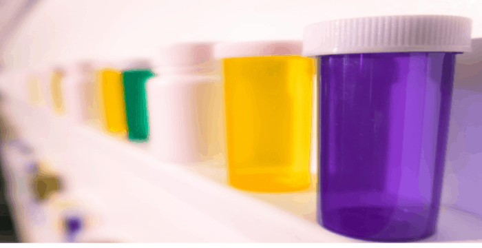 pill bottles lined up on white shelf