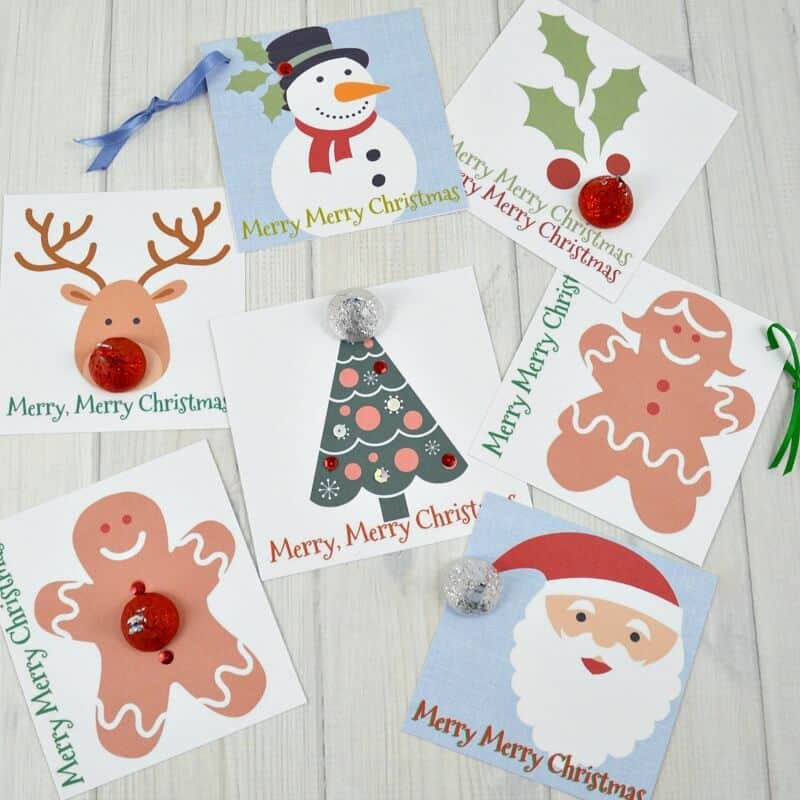 Overhead view of 7 Christmas cards with candy and ribbons