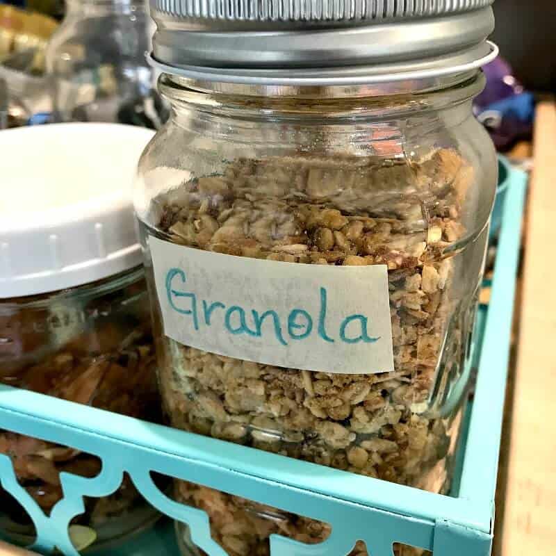 glass jar of granola with masking tape and blue label in blue tray