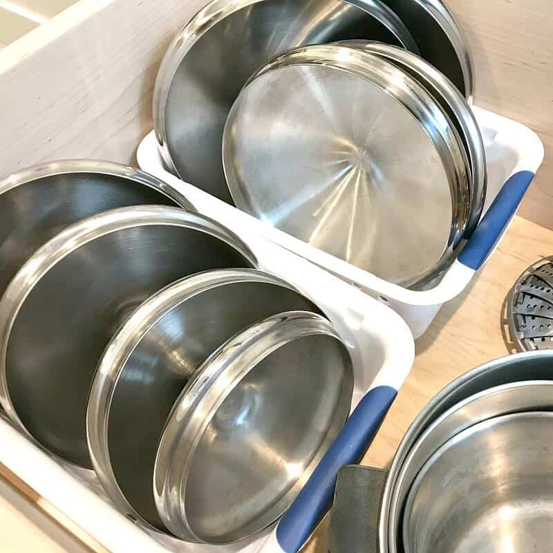 Pot lids filed vertically in baskets in a drawer