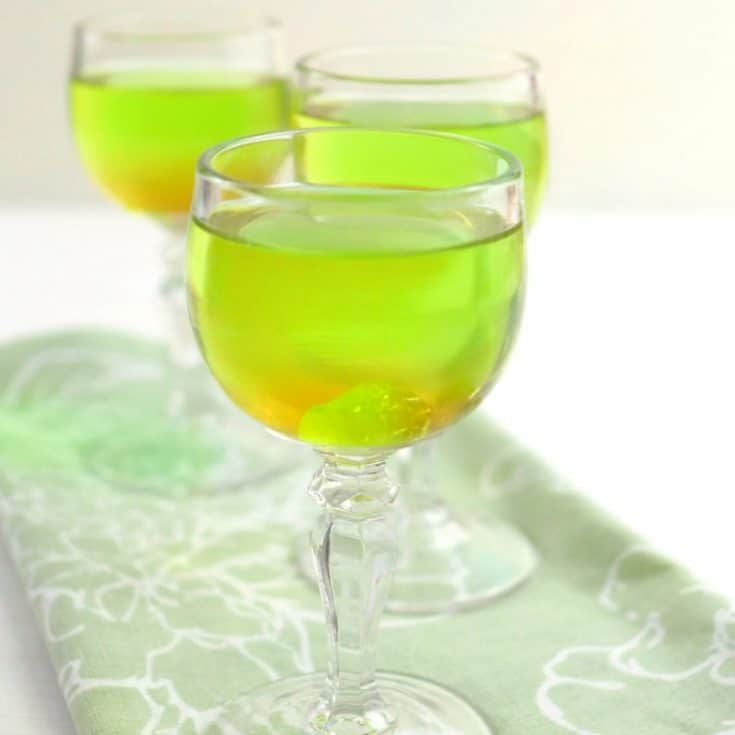 3 glasses with green liquid and green jolly rancher in cup