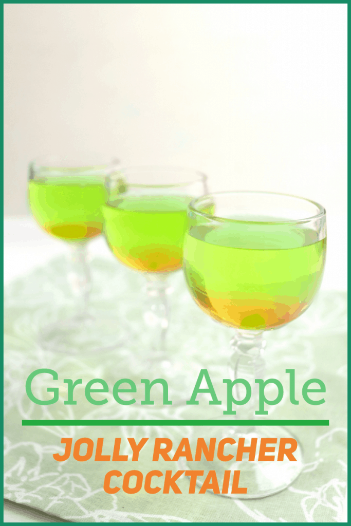 3 wine glasses of green and orange drink on green table cloth